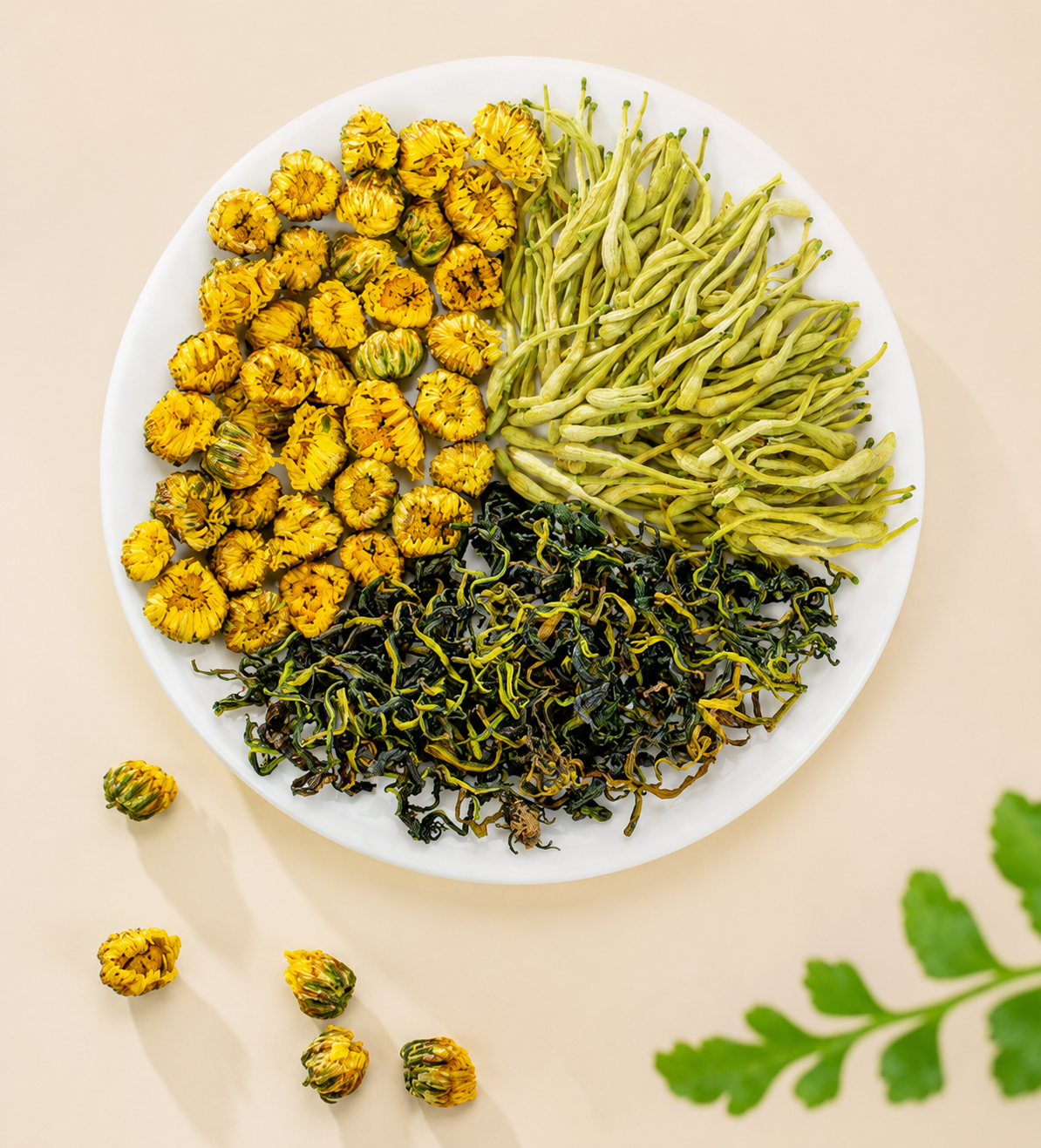 Dried chrysanthemum, honeysuckle buds, and leafy botanical tea arranged on a plate